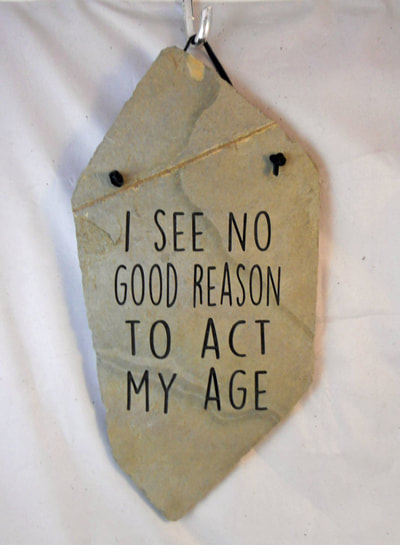 Engraved rock gifts with "i see no reason to act my age" sign and plaques