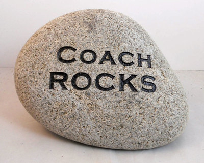engraved rock that says Coach Rocks