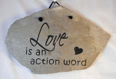 Love is an action word engraved stone sign