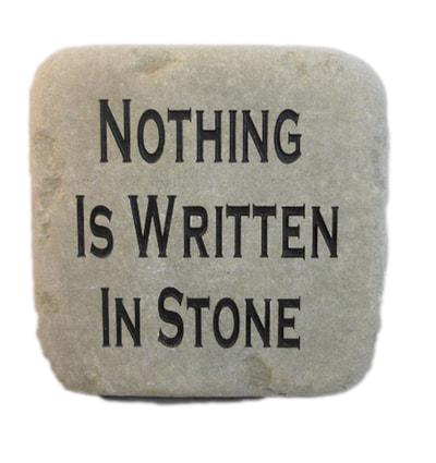 engraved rock sign and plaque that say "nothing is written in stone"